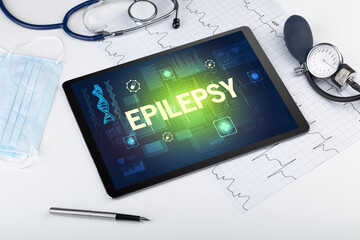 Tablet pc and medical stuff with EPILEPSY inscription, prevention concept