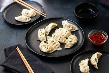 Delicious gyoza dumplings  on black plates  with soy sauce and chili oil. selective focus