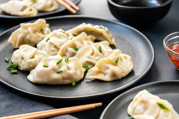 Delicious gyoza dumplings  on black plates  with soy sauce and chili oil. selective focus