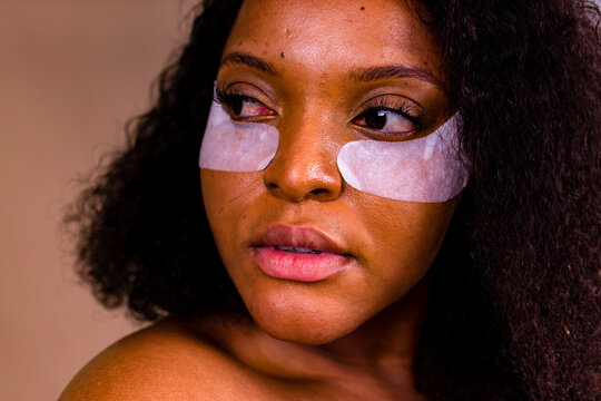 beautiful hispanic woman with collagen patches undereye patch wrinkles in brown background unretouched photo