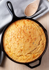 Cornbread in cast iron skillet with spoon flat lay