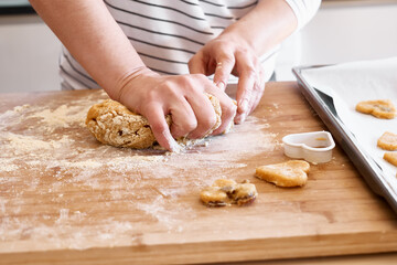 Woman kneading dough for cookies on the table in the kitchen. Gluten free flour cookies. Homemade healthy eating.