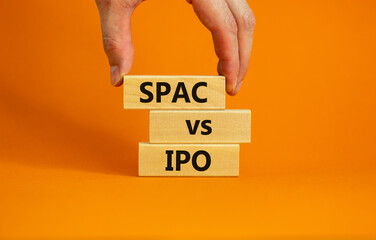 SPAC vs IPO symbol. Blocks with words 'SPAC, special purpose acquisition company' and 'IPO, initial public offering' on orange background, copy space. Business and SPAC vs IPO concept.