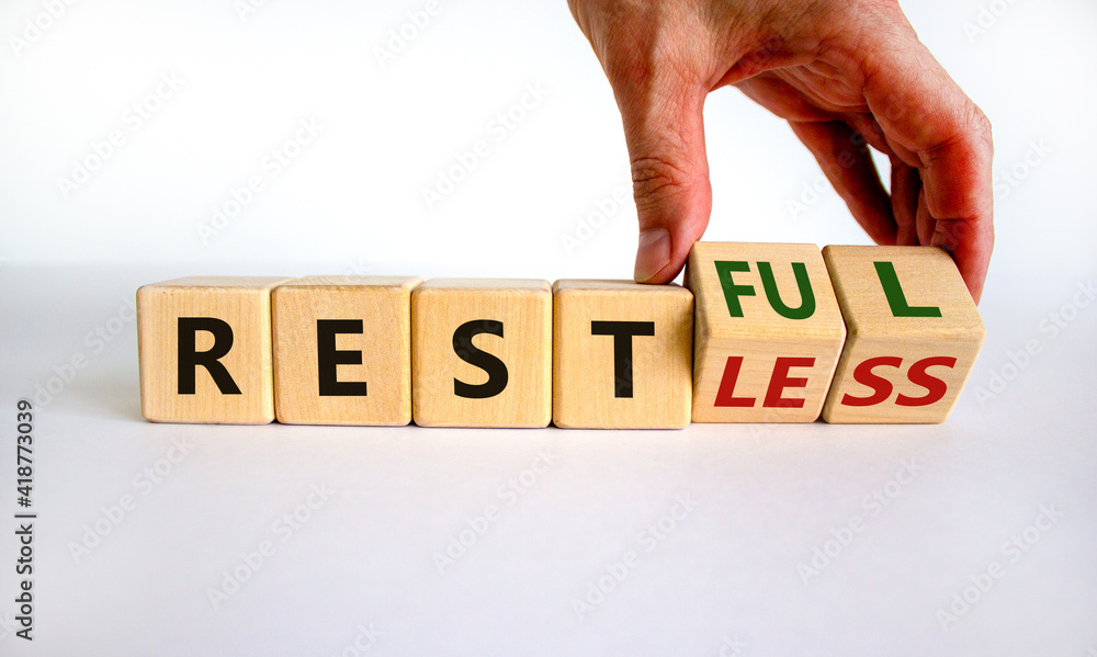 Fototapete restless or restful symbol. businessman turns wooden cubes, changes the word 'restless' to 'restful'