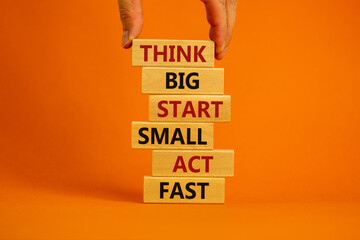 Think big start small symbol. Words 'Think big start small act fast' on wooden blocks on a...