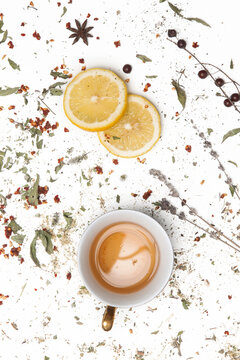 Herbal tea, top view. Dry herbs, lemon slices and tea cups on white. Herbs in bulk, zero waste and eco-friendly lifestyle, herbal medicine concept. © triocean