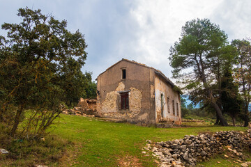 Fototapeta na wymiar abandoned country house in a Mediterranean forest, on a cloudy day.