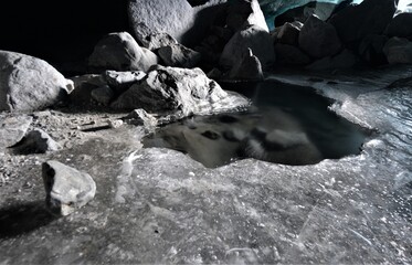 Glacier grotto ice water with clear ice and stones