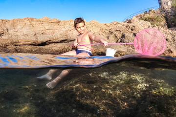 Little boy fishing on the sea with a fishnet