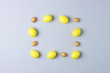 Easter yellow and golden eggs on grey background. Flat lay, copy space.