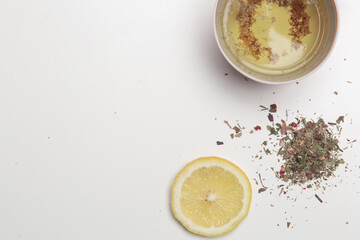 Herbal tea, top view with copy spce. Dry herbs, lemon slices and tea cups on white. Herbs in bulk, zero waste and eco-friendly lifestyle, herbal medicine concept.	