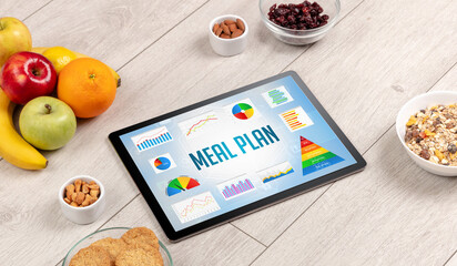Organic food and tablet pc showing MEAL PLAN inscription, healthy nutrition composition