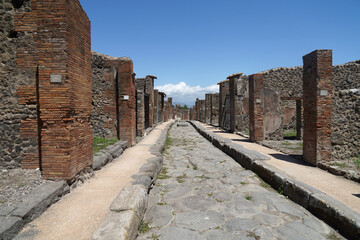 Main street with sidewalks in Pompeii famous ancient city archaeological site near Mount Vesuv, popular tourist guided tour destination, Pompei, Italy