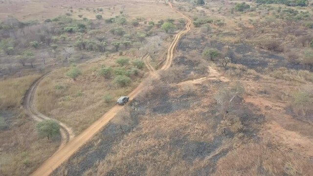 Aerial Shot Of A Truck Driving Through Burned Field and Forest, Madagascar
