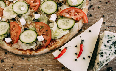 Vegetable pizza with mozzarella, fresh tomatoes and cucumber. Two types of blue cheese