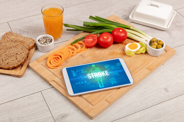 STROKE concept in tablet with fruits, top view