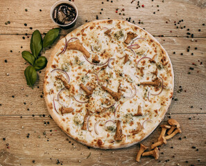 Pizza with chanterelles and chicken. Spicy basil leaves