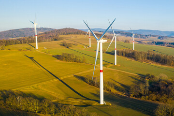Panoramic view of wind farm or wind park, with high wind turbines for generation electricity with...