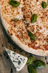 Golden margarita pizza decorated with basil leaves with blue cheese
