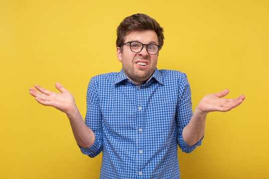 Confused clueless man shrugging shoulders, making no idea gesture, whatever.