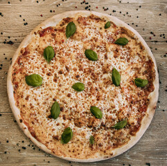 Golden margarita pizza decorated with basil leaves