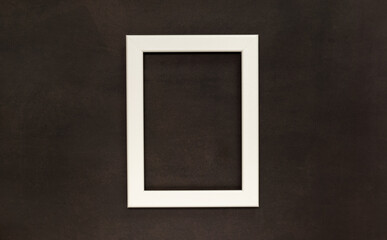 White wooden photo frame on the black background. Mock-up backdrop with space for copy....
