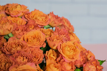 A part of huge bouquet of roses, against white brick wall background.	