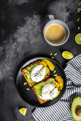 Sandwich with avocado and Poached Egg. Wholemeal Bread Toast sliced avocado and egg with cup of coffee for healthy breakfast or snack, copy space.