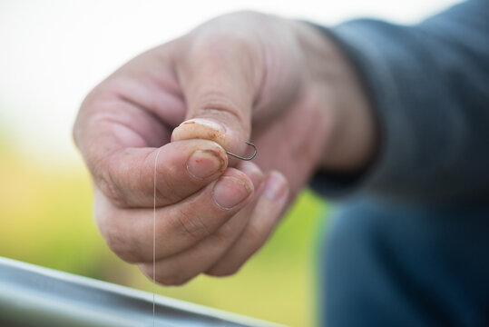 Fisherman Is Holding An Empty Fishing Hook In The Hand Close Up.