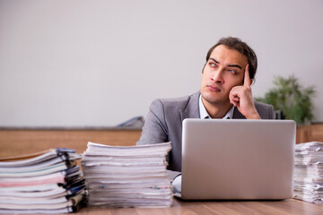 Young male employee unhappy with excessive work in the office