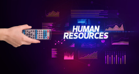 hand holding wireless peripheral with HUMAN RESOURCES inscription, cyber business concept