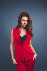Fototapeta premium Beautiful sexy brunette woman wear red silk costume jacket and pants summer collection clothes for business lady casual work office style make a pose fashion model catalog