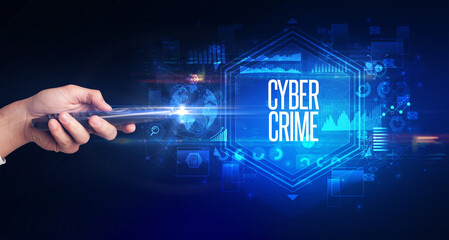 hand holding wireless peripheral with CYBER CRIME inscription, cyber security concept