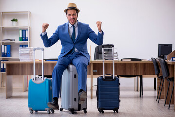 Young male employee preparing for trip in the office