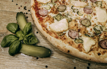 Super cheesy pizza with hunting sausages, pickles and melted cheese