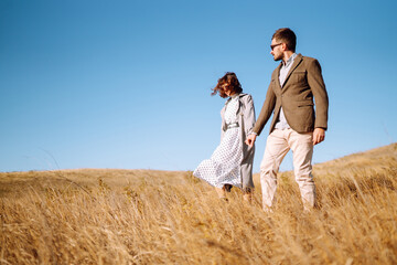 Stylish and loving couple enjoying each other outdoors. Young couple walking and hugging. Springtime.