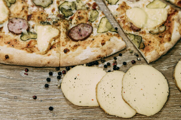 Super cheesy pizza with hunting sausages, pickles and melted cheese