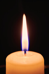 One candle flame in night dark. Close up view with copy space