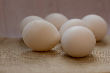 chicken eggs on a wooden and fabric background burlap