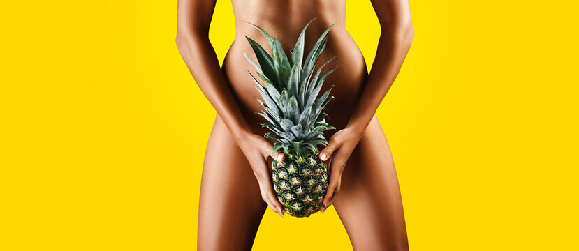  Young woman holding a pineapple in her hand