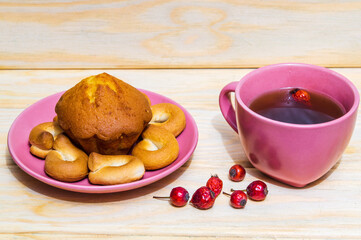 Homemade round bagels with muffins in a purple plate and rosehip tea. Idea for a delicious breakfast or dinner.