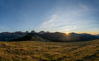 swiss mountains during sunset with fog and clouds and snowy mountains in the alps