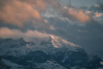 Plakat swiss mountains during sunset with fog and clouds and snowy mountains in the alps