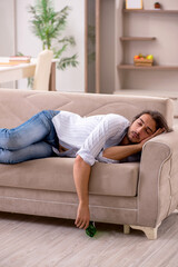 Fototapeta premium Young man drinking alcohol at home