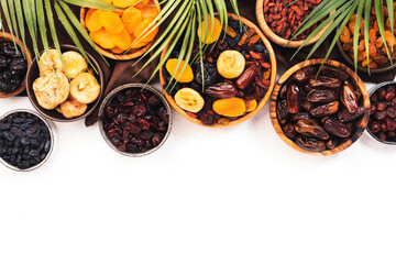 Healthy food snack: dried fruits, natural. sun dried organic mix of dried apricots, figs, raisins, dates, cranberries, cherries, goji berries, prunes in bowls on white background, top view