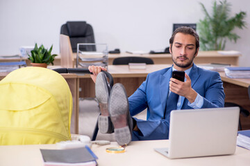 Young male employee looking after new born at workplace