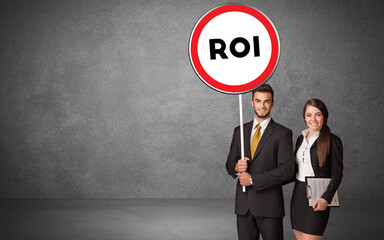 Young business person holdig traffic sign with ROI abbreviation, technology solution concept