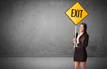 Young business person holding road sign with EXIT inscription, new rules concept