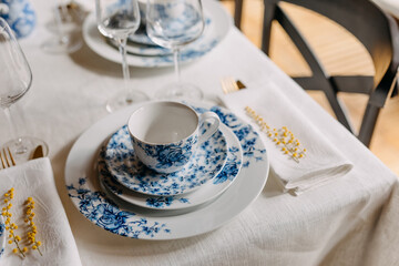 Vintage porcelain cup and plates on table at breakfast.