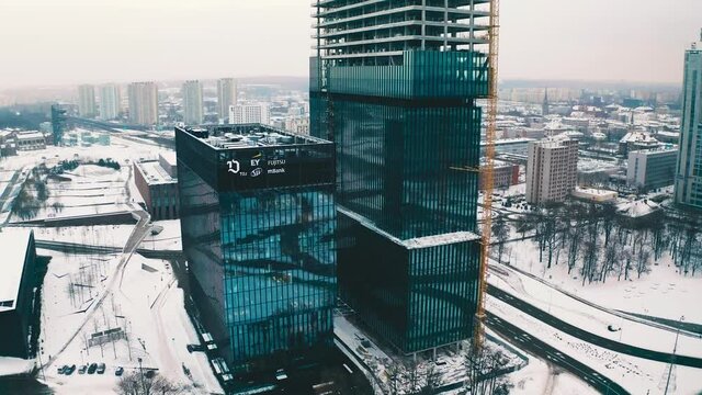 Modern glass office skyscrapers under construction .KTW in Katowice, Poland in snowy winter aerial drone view 4k